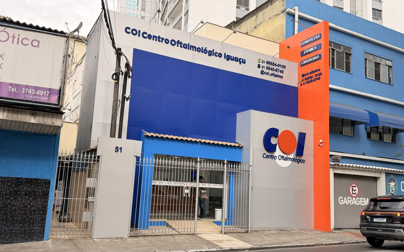Fachada azul do COI na R. Comendador Soares, 51, com o letreiro e a bola laranja do logotipo